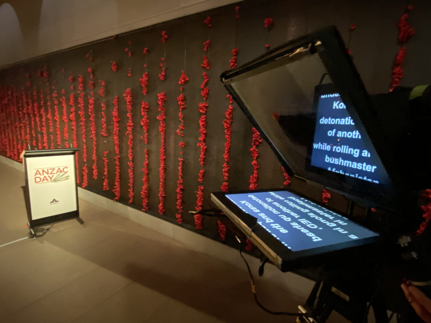 A large screen monitor on display in front of a wall.