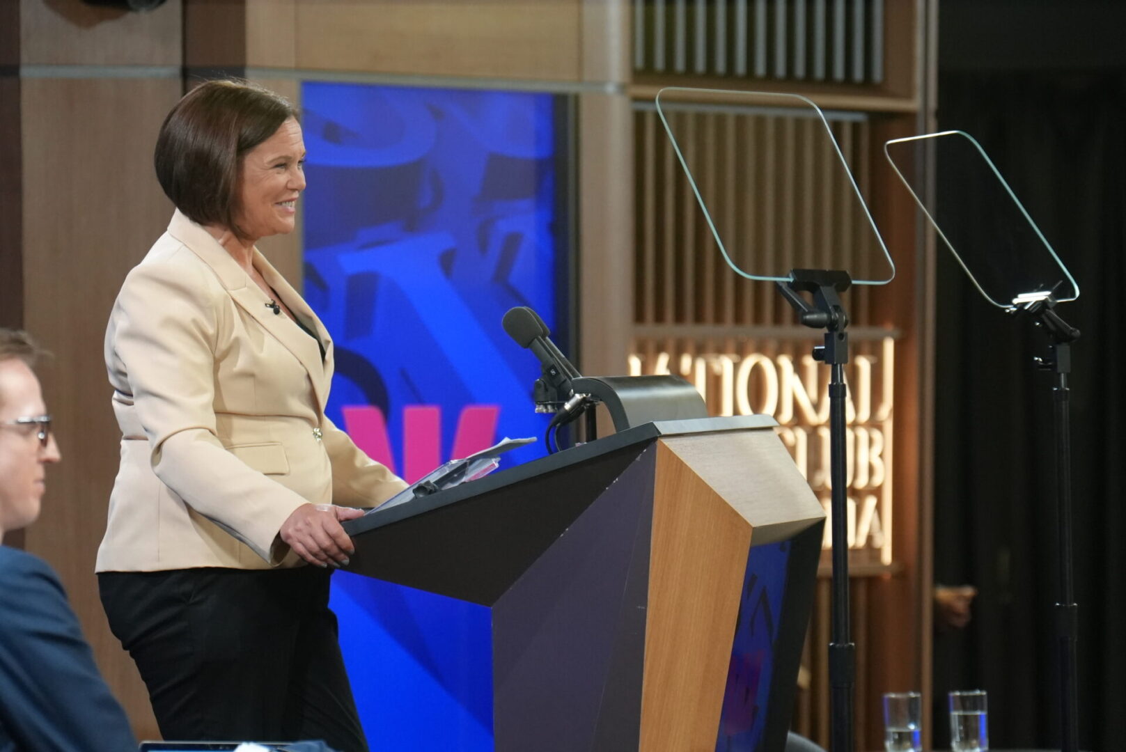A woman standing at the podium speaking to an audience.