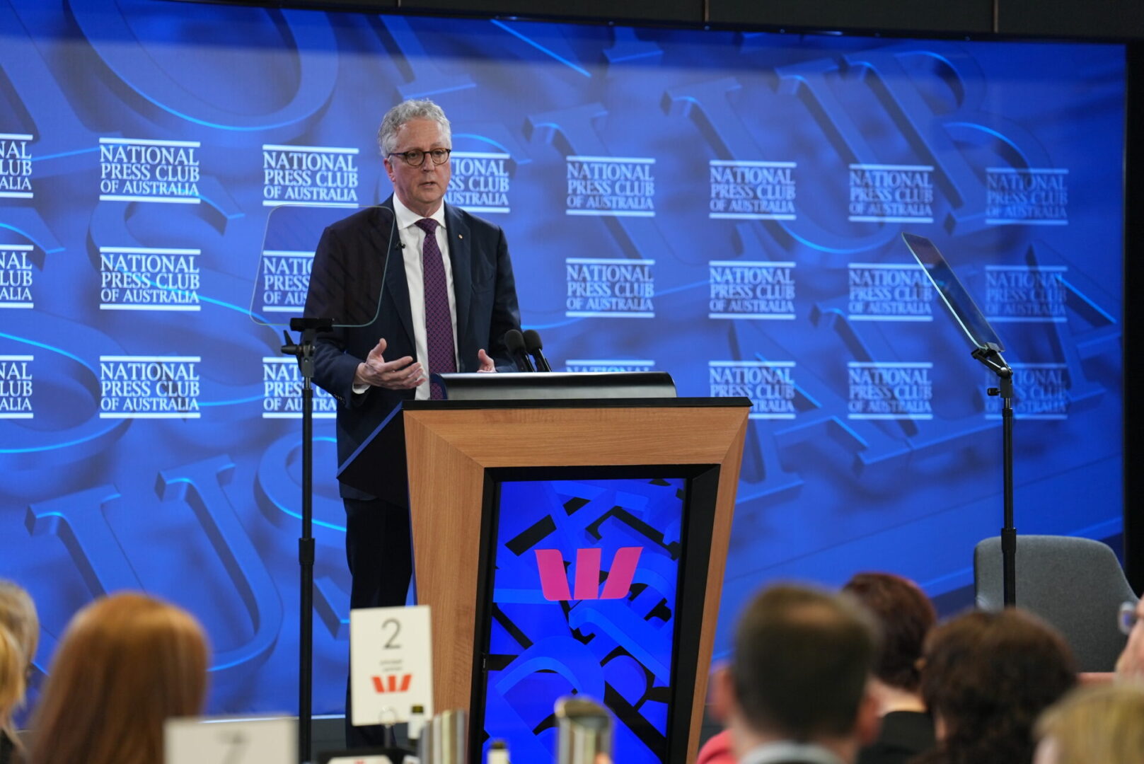 A man standing at a podium in front of a crowd.