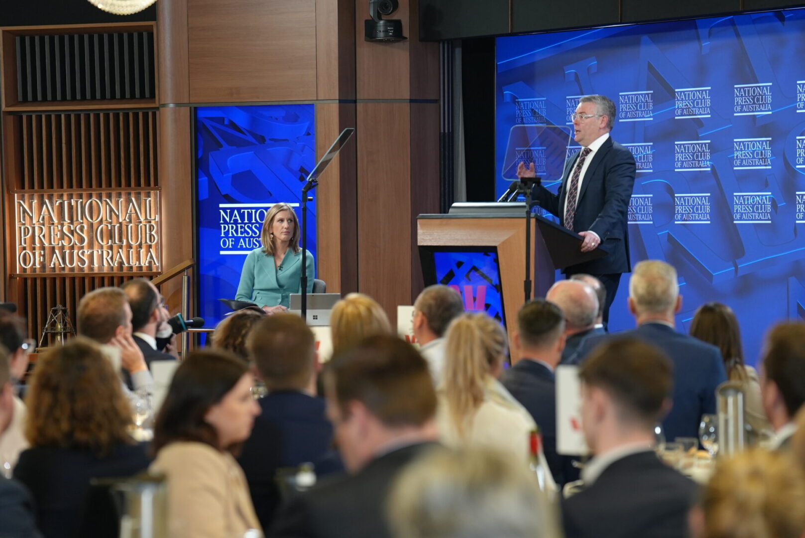 A man is giving a speech to an audience.